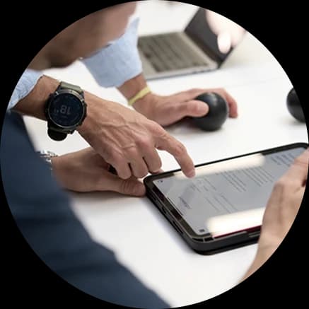 Manos trabajando sobre una tablet y un portátil en una sesión de trabajo